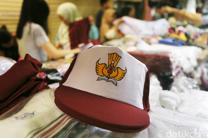 Calon pembeli mencoba baju seragam sekolah yang dijual di salah satu toko di Pasar Baru, Jakarta, Minggu (4/7). Sejumlah toko penjualan perlengkapan sekolah mulai dipenuhi orang tua siswa yang membeli seragam untuk tahun ajaran baru yang akan dimulai Senin (10/7). (Ari Saputra/detikcom)