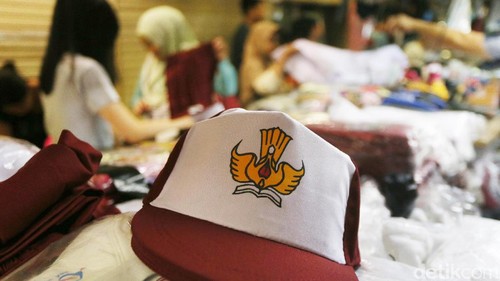 Calon pembeli mencoba baju seragam sekolah yang dijual di salah satu toko di Pasar Baru, Jakarta, Minggu (4/7). Sejumlah toko penjualan perlengkapan sekolah mulai dipenuhi orang tua siswa yang membeli seragam untuk tahun ajaran baru yang akan dimulai Senin (10/7). (Ari Saputra/detikcom)