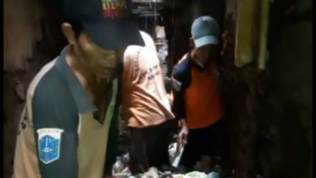 Petugas kebersihan sibuk membersihkan sampah-sampah.