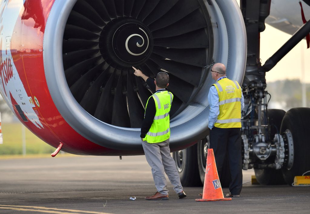 Officials inspect an engine of Malaysian budget carrier AirAsia X after it was diverted and forced to land because an engine was damaged during take-off by what was thought to be a bird strike at Brisbane Airport in Australia, July 4, 2017.    AAP/Darren England/via REUTERS    ATTENTION EDITORS - THIS IMAGE WAS PROVIDED BY A THIRD PARTY. NO RESALES. NO ARCHIVE. AUSTRALIA OUT. NEW ZEALAND OUT.     TPX IMAGES OF THE DAY