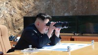 Kim Jong Un memantau proses peluncuran Hwasong-14 dengan teropong. KCNA/via REUTERS.