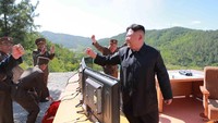 Kim Jong Un tampak gembiran dengan peluncuran misilnya. KCNA/via REUTERS.