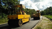 Sesekali tampak pekerja dan alat berat untuk pembangunan jalan di ruas jalan tersebut. Pada bagian jalan yang belum beraspal, pekerjaan juga tampak dilakukan mulai pemadatan struktur tanah hingga pengerasan seperti pengaspalan. Foto: dok. Kementerian PUPR 
