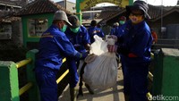 Petugas mengangkut sampah.