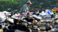 Seorang petugas tampak melakukan pengerukan sampah-sampah yang sudah terlanjur menggunung itu.