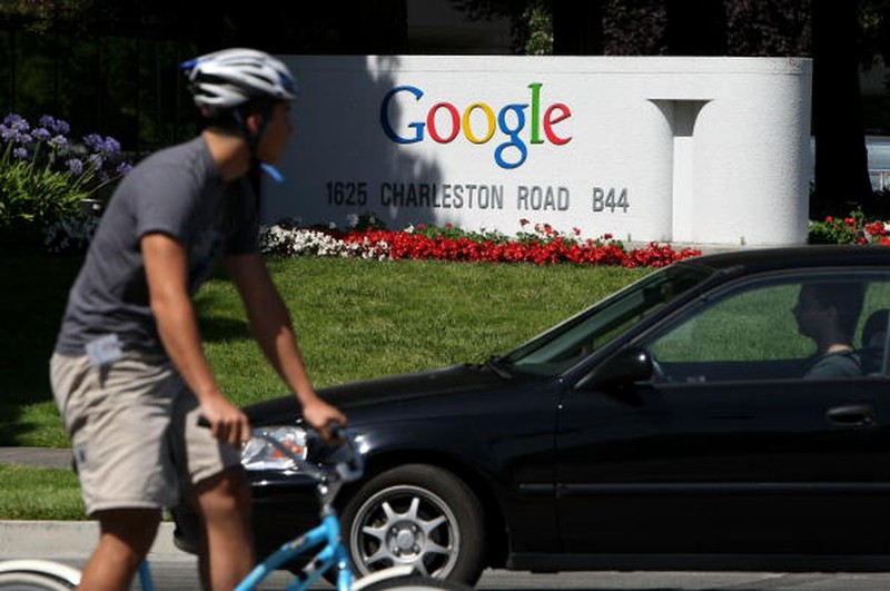 MOUNTAIN VIEW, CA - JULY 17:  A bicyclist rides by a sign outside of the Google headquarters July 17, 2008 in Mountain View, California. Google Inc. is expected to announce an increase in quarterly profits when it reports its quarterly earnings today after the closing bell.  (Photo by Justin Sullivan/Getty Images)