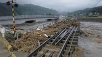 Kayu-kayu yang terbawa air banjir menumpuk di rel kereta. Kyodo/via REUTERS.