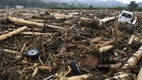 Banjir ini membawa ribuan batang kayu yang menumpuk di kota, Kamis (6/7). Kyodo/via REUTERS.
