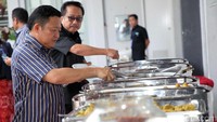 Mantan Bupati Amran Batalipu dan mantan Dirjen ESDM Waryono Karyo menyantap makanan yang dihidangkan dalam acara pertemuan.