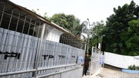 Petugas keamanan berjaga di gerbang masuk.