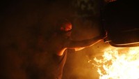 Seorang demonstran membakar keranjang sampah. Hannibal Hanschke/Reuters.