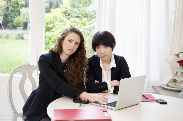 Portrait of two business woman using laptop