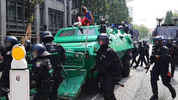 Salah satu demonstran nekat menaiki mobil barakuda polisi