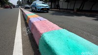 Biasanya, pembatas jalan yang selalu dicat berwarna hitam dan putih, namun di Jalan TB Simatupang, Pasar Rebo, Jakarta Timur, tampil dengan penuh warna.