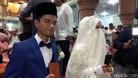 Senyum kebahagiaan terpancar pada pasangan tersebut. Keduanya memegang buku nikah sebagai tanda telah sah sebagai suami istri. (Foto: Agus Setyadi)