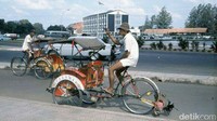 Pengendara becak melintasi kawasan bunderan Hotel Indonesia dengan latar belakang ex-Kedutaan Besar Inggris. (Foto: Istimewa)