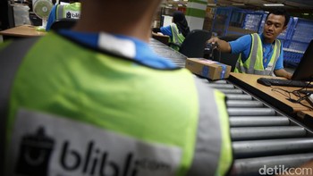 Seorang pekerja mengecek kualitas dan pengemasan barang yang akan dikirim.