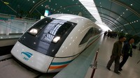 Sejumlah penumpang di Shanghai melintas di antara kereta cepat China dengan sistem levitasi magnetik. Kereta ini mampu menempuh kecepatan hingga 450 km/jam. Getty Images.