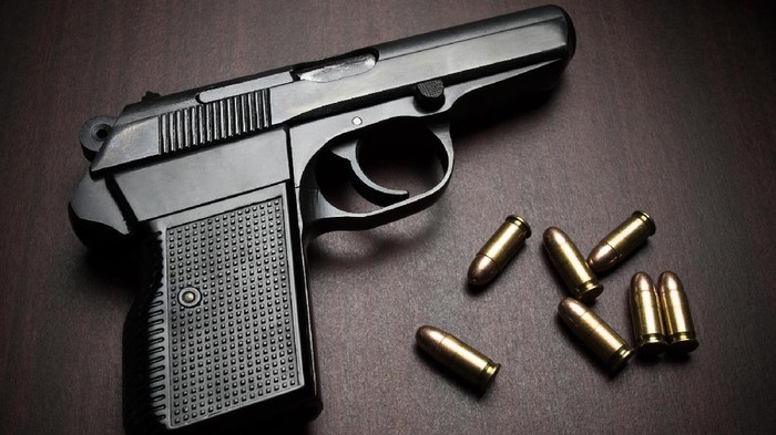 handgun with bullets on the wooden surface, closeup with vignette, useful for various security,protection or criminal topics