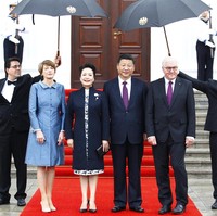 Saat bertemu Presiden Jerman Frank-Walter Steinmeier dan istrinya, Peng Liyuan mengenakan dress putih bermotif floral berbalut coat biru navy yang dipercantik dengan bros bernuansa oriental. (Foto: Getty Images)