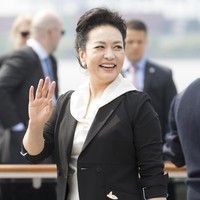 Peng Liyuan tampak memilih blazer hitam untuk membungkus blouse dan celana panjang serba putih. (Foto: Getty Images)