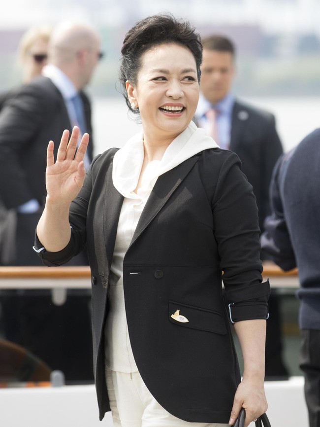 Peng Liyuan tampak memilih blazer hitam untuk membungkus blouse dan celana panjang serba putih. (Foto: Getty Images)