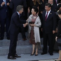 Ketika bertemu dengan para kepala negara beserta pasangannya, Peng Liyuan memilih cheongsam-dress coklat yang dipercantik dengan detail bordiran bermotif bunga. (Foto: Getty Images)