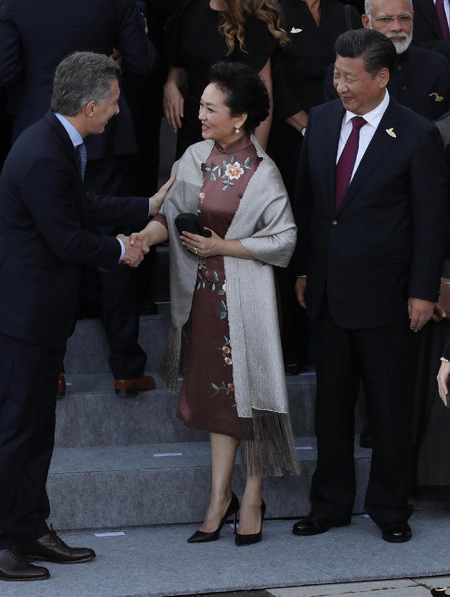 Ketika bertemu dengan para kepala negara beserta pasangannya, Peng Liyuan memilih cheongsam-dress coklat yang dipercantik dengan detail bordiran bermotif bunga. (Foto: Getty Images)