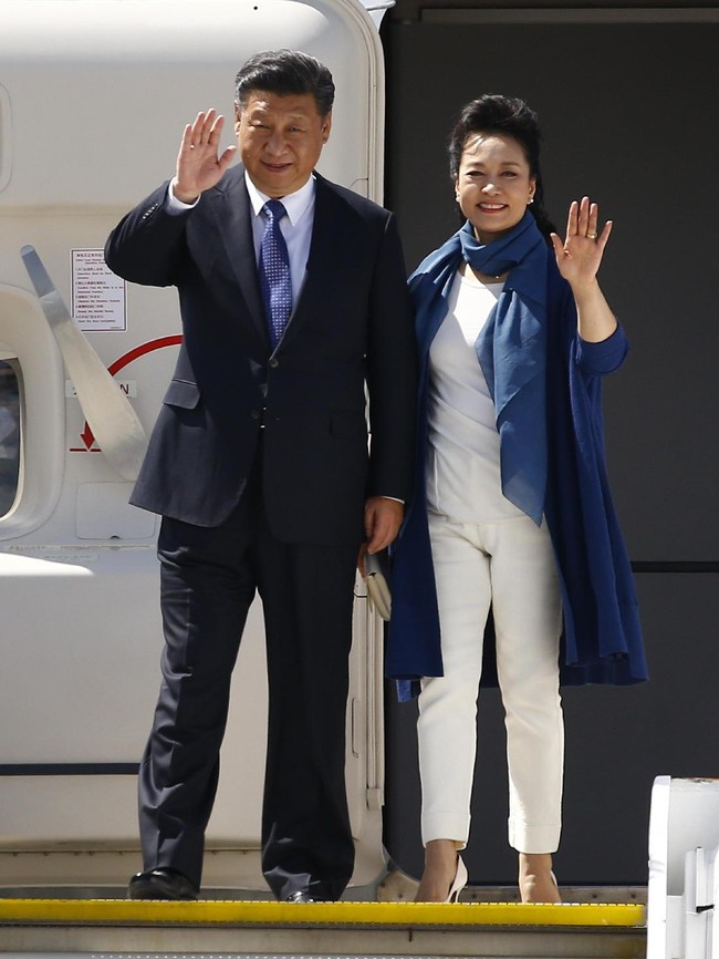 Peng Liyuan tiba dalam  balutan atasan dan celana panjang, serta pointed heels serba putih yang dipadu dengan coat dan syal biru mencolok. (Foto: Getty Images)