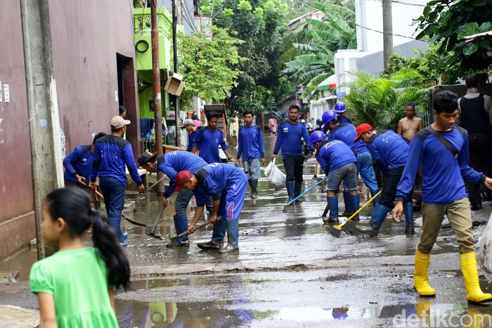 Banjir yang melanda Cipinang Melayu, Jakarta Timur, mulai surut. Petugas Sudin Tata Air DKI Jakarta alias Pasukan Biru terjun ke lokasi untuk membersihkan lumpur sisa banjir.