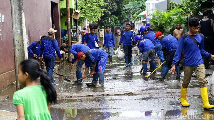 Banjir yang melanda Cipinang Melayu, Jakarta Timur, mulai surut. Petugas Sudin Tata Air DKI Jakarta alias Pasukan Biru terjun ke lokasi untuk membersihkan lumpur sisa banjir.