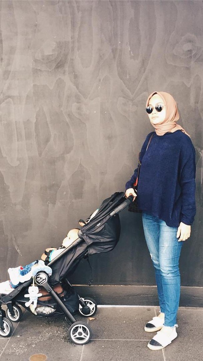 Celana jeans memang paling nyaman dipakai untuk jalan-jalan dengan anak karena santai serta kasual. Gaya hiijab Ayudia Bing Slamet kali ini hanya dipadukan bersama sweater tentu dengan kreasi jilbab yang khas dililitkan merapat ke leher seperti penampilan sehari-harinya. Foto: Dok. Instagram @ayudiac