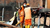 Mereka membongkar kayu-kayu serba menyingkirkan puing-puing.