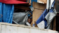 Dari balik rumah warga yang tidak terkena dampak normalisasi Kali Ciliwung, mereka menyaksikan rumah mereka digusur.