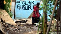 Pemulung mencari barang bekas di rumah-rumah yang akan dihancurkan.
