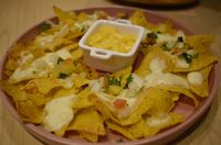Nachos dan keju jadi camilan gurih enak.