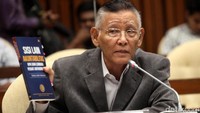 Romli memperlihatkan buku acuan kedudukan KPK dalam sistem peradilan pidana Indonesia. 