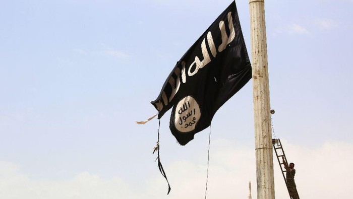 A member of the US-backed Syrian Democratic Forces removes an Islamic State group flag in the town of Tabqa, near Syrias Raqa, on April 30, 2017 (AFP Photo/DELIL SOULEIMAN)
