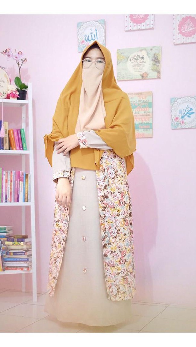 Kali ini Ressa Rere berpenampilan sedikit beda dengan tambahan rompi atau vest pada gamisnya. Menggunakan gamis tersebut Ressa Rere terlihat seperti tidak sedang hamil karena membantu menutupi perutnya. Meski jilbab warna kuning mustard, namun cadarnya kali ini dibuat beda dengan pilihan palet peach yang cerah. Foto: Dok. Instagram @ressarere