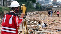 Tampak seorang pekerja telah mengukur untuk proyek normalisasi Ciliwung.
