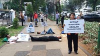 Dalam aksi tersebut, para anggota Koalisi Pejalan Kaki menghalau pemotor yang ingin melintas di trotoar dengan berbaring di jalanan. (Foto: Koalisi Pejalan Kaki)