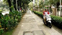 Seorang pemotor terlihat menggunakan jalur pejalan kaki (trotoar) di kawasan menteng, Jakarta Pusat, Minggu (16/7/2017).