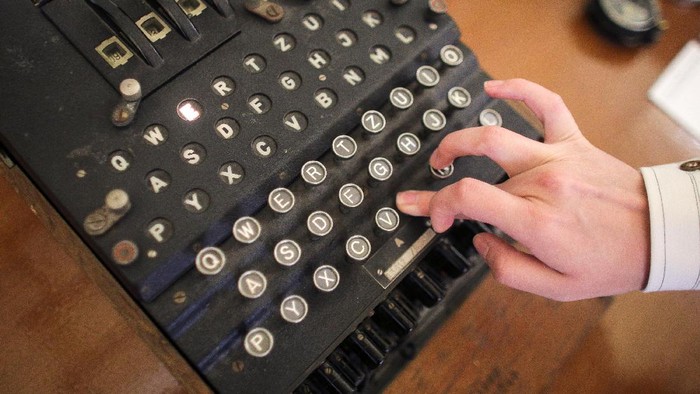 An employee of an auction house presses a key on an working original Enigma cipher machine that is on display at an auction house in Bucharest, Romania, July 11, 2017. Inquam Photos/Octav Ganea/via REUTERS ATTENTION EDITORS - THIS IMAGE WAS PROVIDED BY A THIRD PARTY. ROMANIA OUT.  TPX IMAGES OF THE DAY