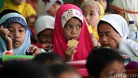 Seorang siswa menyantap bekalnya di dalam kelas.