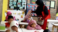 Seorang anak menyalami ibunya sebelum mengikuti pelajaran di hari pertama masuk sekolah.