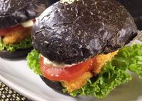 Burger hitam dengan isian fish fingers.