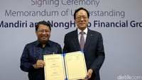 Wakil Direktur Utama Bank Mandiri Sulaiman A Arianto (kiri) dan Chairman & CEO NongHyup Financial Kim Yong Hwan (kanan) usai penandatanganan nota kesepahaman sejumlah bisnis perbankan di Plaza Mandiri, Jakarta (17/7/2017).