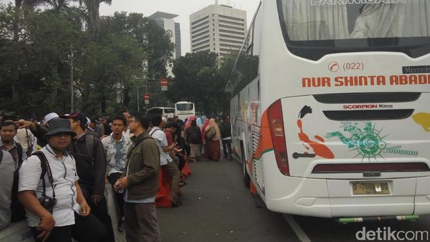 Massa menunggu bus untuk meninggalkan lokasi aksi