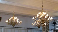 Lampu-lampu hias berukuran besar menghiasi ruangan istana.