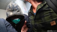 Ia tampak menutupi wajahnya dengan masker serta hoodie bermotif army. Pool/Ismail/detikFoto.